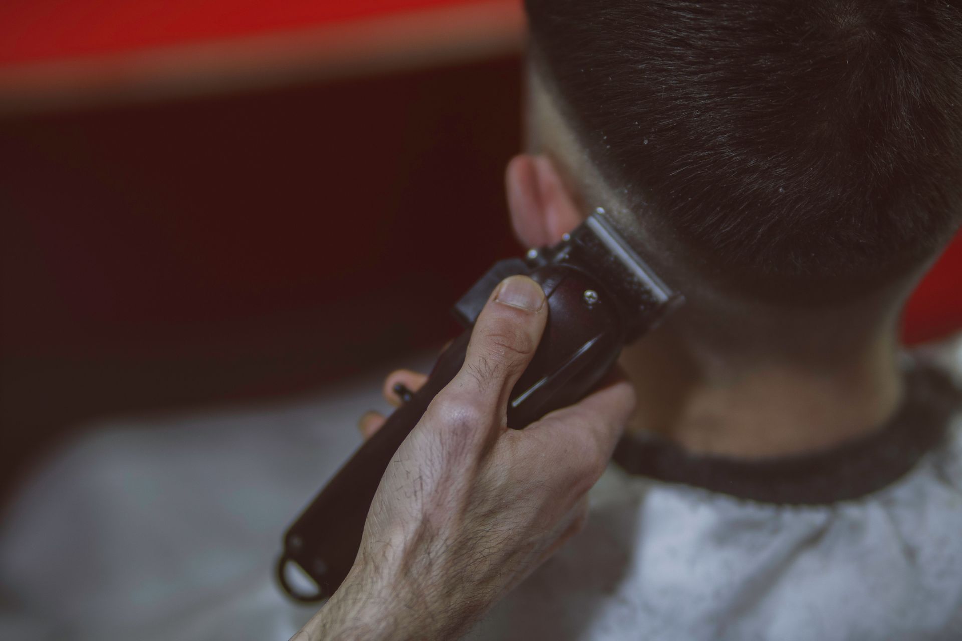 Close-up view of a man getting a haircut with clippers, highlighting the precise technique.